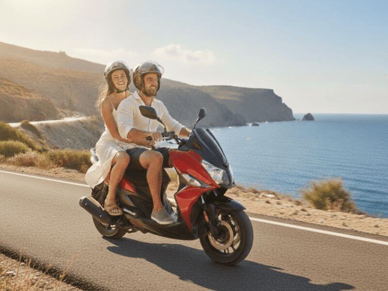Happy couple enjoying a scenic coastal drive on a rental scooter in Crete.